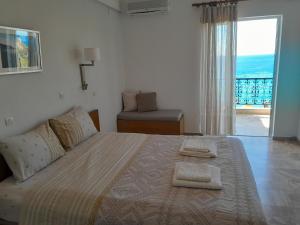 a bedroom with a large bed with a view of the ocean at Livikon Studios & Rooms in Rodakino