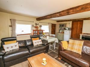 a living room with a leather couch and a table at The Bake House in Bridgend