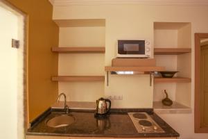 a kitchen with a sink and a microwave at Comfortable Flat with Jacuzzi near Hadrian's Gate in Antalya