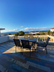 a patio with a table and chairs on a roof at The Dona House in Vaia