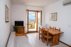 una sala da pranzo con tavolo e TV di Gardenia Casa Vacanze ad Alghero