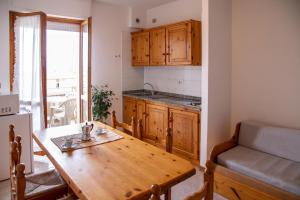 una cucina con tavolo in legno e una sala da pranzo di Gardenia Casa Vacanze ad Alghero
