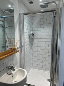 y baño con ducha y lavamanos. en Beautiful, spacious 3 bed Brixham apartment, en Brixham