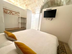 een slaapkamer met een bed en een tv aan de muur bij B&B Suite Amare Polignano in Polignano a Mare