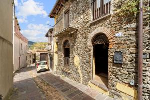 a stone building with a car parked on a street at Su Cuccumeu 