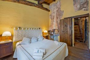 a bedroom with a white bed with towels on it at Su Cuccumeu 