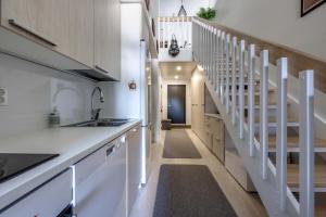 a kitchen with white counters and a stairway at Hilmantori 310 lomahuoneisto in Kalajoki