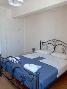 a blue and white bed with towels on it at Sofirene II in Batsi
