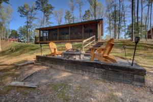 een blokhut met 2 stoelen en een vuurplaats bij Goldyloks' Cottage is "Just Right!" for you! Near Murphy, NC and Blairsville, GA in Murphy