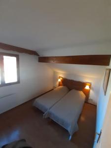 代沃呂伊的住宿－Chalet 6-8 couchages à la Joue du Loup，一间卧室配有一张带两个灯的床
