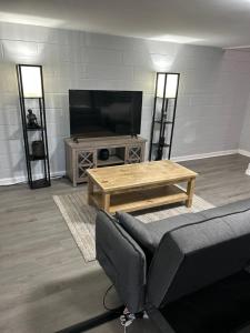 a living room with a couch and a television at The Tranquil Lodge in Clarksville