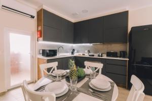 eine Küche mit Tisch und Stühlen und eine Küche mit schwarzen Schränken in der Unterkunft Best Houses 79 - PénAreia in Peniche