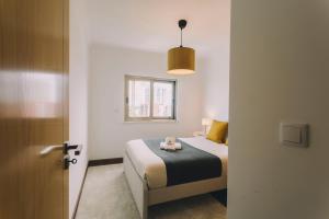 ein Schlafzimmer mit einem Bett mit zwei Teddybären darauf in der Unterkunft Best Houses 74 - SurfSide Lodge in Peniche