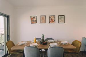 einen Esstisch mit Stühlen und einen Tisch mit Tellern in der Unterkunft Best Houses 74 - SurfSide Lodge in Peniche