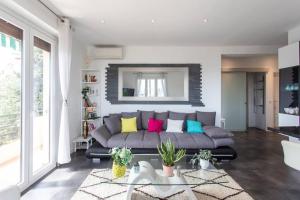 salon z szarą kanapą i kolorowymi poduszkami w obiekcie L27 2P Jasmins Sea View Parking & AC w Nicei