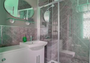 a bathroom with a sink and a shower with a mirror at Hideout in Felixstowe