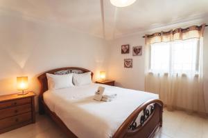 een slaapkamer met een groot wit bed met 2 lampen bij Best Houses 45 - Beautiful ocean and city view in Peniche
