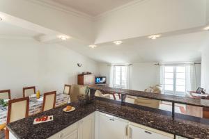 een keuken met granieten aanrechtbladen en een woonkamer bij Best Houses 45 - Beautiful ocean and city view in Peniche