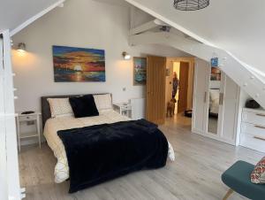 een slaapkamer met een bed met een zwarte deken bij Beautiful, spacious 3 bed Brixham apartment in Brixham