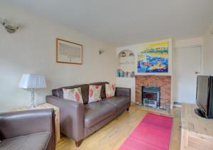 uma sala de estar com um sofá e uma lareira em Horseshoe Cottage em Southwold