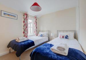 um quarto com 2 camas e toalhas em Horseshoe Cottage em Southwold