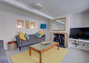 a living room with a couch and a fireplace at James Cottage in Southwold