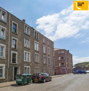 a car parked on a street next to a building at Kingscross Neuk - City Base in Dundee