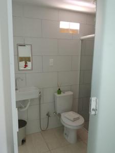 a white bathroom with a toilet and a sink at Pousada Aconchego do Maraca in Porto De Galinhas