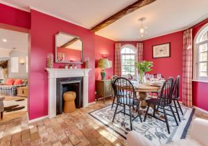 a dining room with red walls and a table and chairs at Ivy Lodge in Rendlesham