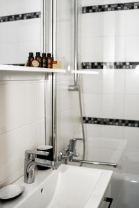 La salle de bains est pourvue d'un lavabo et d'une douche. dans l'établissement Vilnius Centrum Apartment, à Vilnius