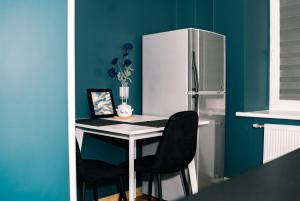 a kitchen with a desk with a refrigerator and chairs at Vilnius Centrum Apartment in Vilnius