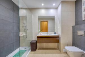 uma casa de banho com um chuveiro, um lavatório e um WC. em Rocha Prime Luxury Apartment em Portimão