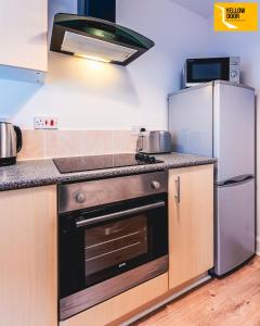 a kitchen with a stove and a refrigerator at Kingscross Neuk - City Base in Dundee