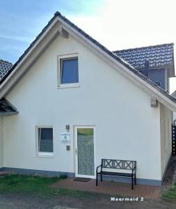 een wit huis met een bankje ervoor bij Meermaid 1 in Plau am See