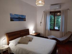 1 dormitorio con 1 cama, 1 silla y 1 ventana en Al Casalino House en Ronciglione