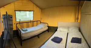 a room with two beds in a tent at 'Glamping' Angelzelt am See mit Steg und Boot (Mecklenburger Seenplatte) in Blankensee