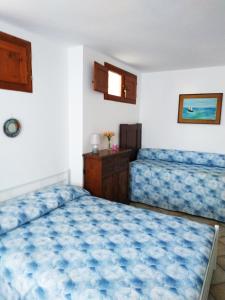 a bedroom with two beds with blue sheets at Casa con vista sul golfo vicina al mare in Santa Luria