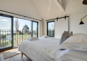 een slaapkamer met een groot bed en een groot raam bij Leveretts in Walberswick