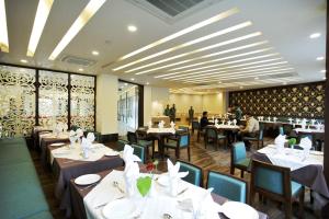 a restaurant with tables and chairs and people in the background at Lemon Tree Hotel, Katra in Katra