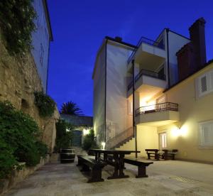 a building with benches in front of it at night at Luxury Apartment Spa "Marina" in Makarska
