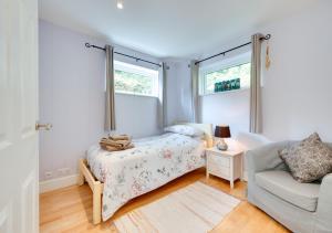 a small bedroom with a bed and a couch at Little Glebe in Middleton