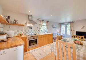 a kitchen with wooden cabinets and a table with a dining room at Little Glebe in Middleton