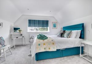 a bedroom with a blue bed and a desk at Loxwood in Reydon