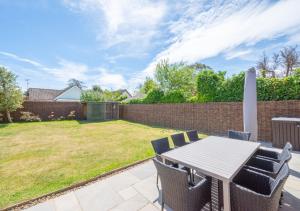 a patio with a table and chairs in a yard at Loxwood in Reydon