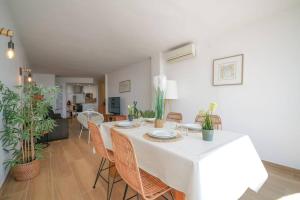 a dining room with a white table and chairs at Magnifique duplex, vue mer et canal by Welhomy in Empuriabrava