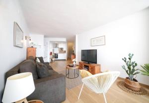 a living room with a couch and a tv at Magnifique duplex, vue mer et canal by Welhomy in Empuriabrava
