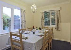 a dining room with a table and chairs and windows at Manor Lodge in Southwold