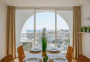 a dining room with a table and a large window at Magnifique duplex, vue mer et canal by Welhomy in Empuriabrava