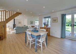 a kitchen and living room with a table and chairs at Lodge Farm Barn in Sudbourne