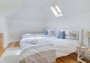 a bedroom with a large white bed with blue pillows at Lodge Farm Barn in Sudbourne